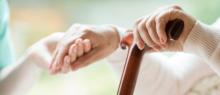 woman with cane holding her daughter's hand