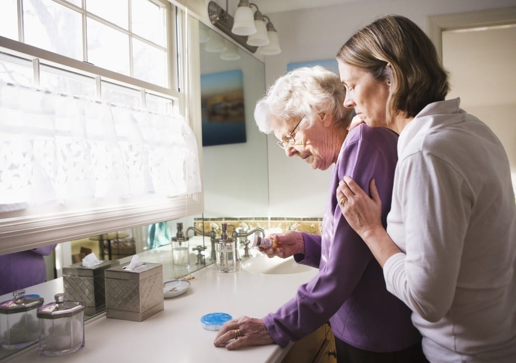 caregiver helping elderly mother at a bathroom counter