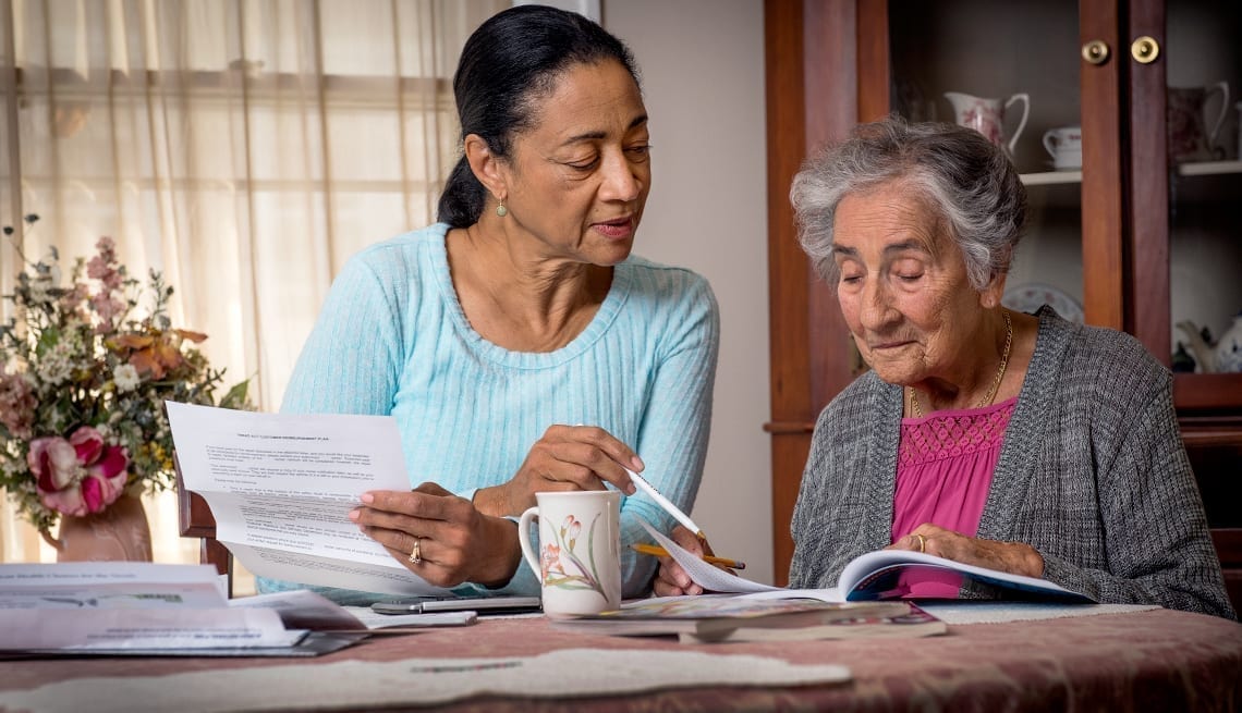 caregiver helping elderly with paperwork