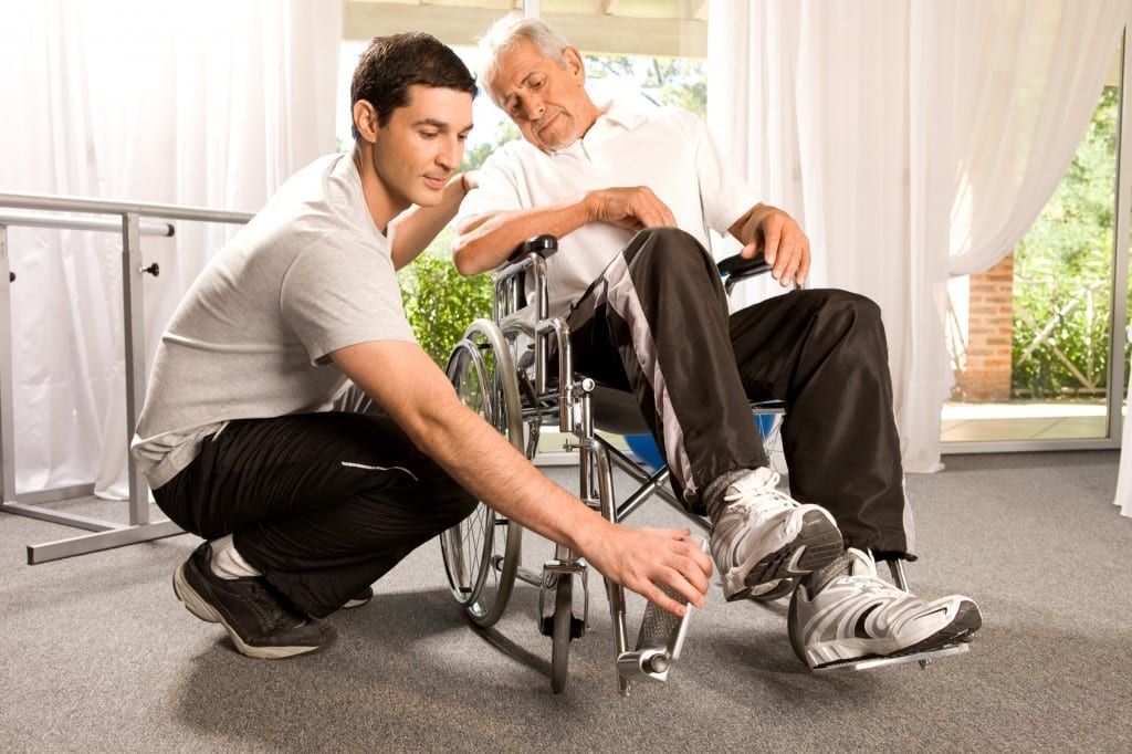 young caregiver helping grandfather with wheelchair