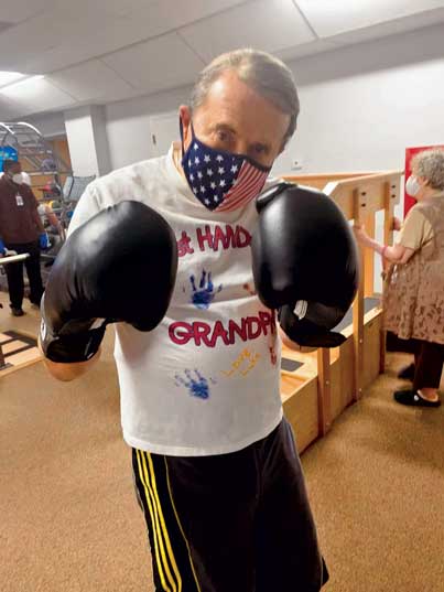 Glencroft resident with mask on wearing boxing gloves