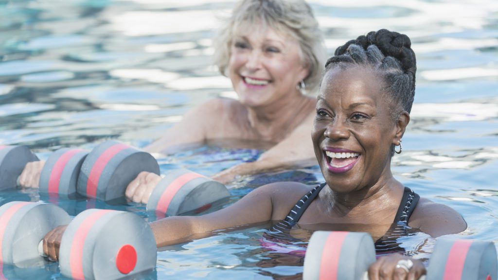 Senior woman and friend doing water aerobics