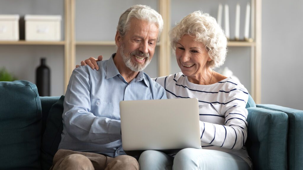 senior couple looking at long term care insurance on a laptop at home