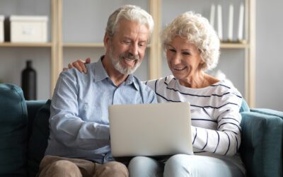 senior couple looking at long term care insurance on a laptop at home