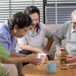 older adults playing jenga at home, one of the best sit down games for senior citizens
