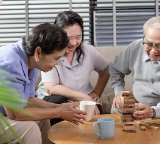 older adults playing jenga at home, one of the best sit down games for senior citizens