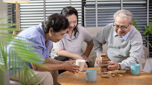 older adults playing jenga at home, one of the best sit down games for senior citizens