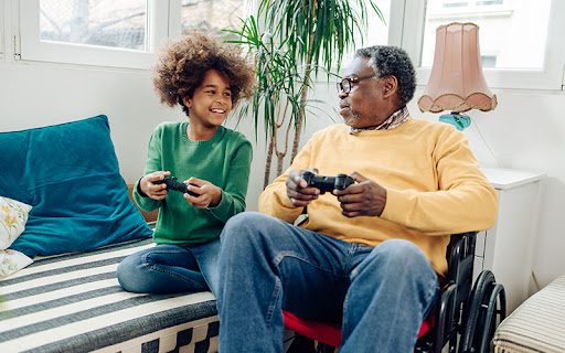 senior man playing video games with his family