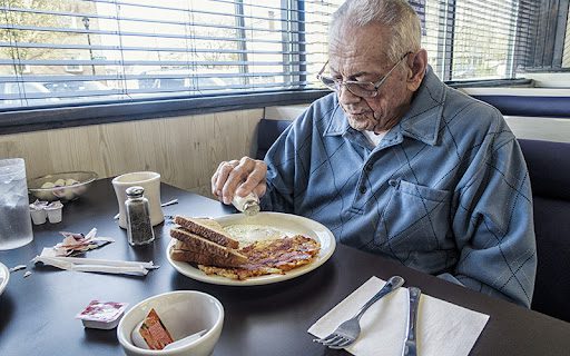 senior man enjoying a discounted meal at Denny's