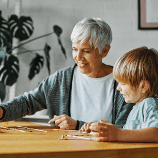 active older adult playing scrabble with young child